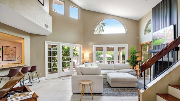 A spacious living area with a large sectional sofa, a coffee table, and a staircase leading to an upper level. - Bright Phoenix Oasis w/Private Pool & Mtn Views (Phoenix)