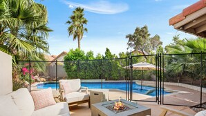 A poolside area with lounge chairs, a fire pit, and a view of a swimming pool and palm trees. - Bright Phoenix Oasis w/Private Pool & Mtn Views (Phoenix)