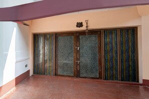 Ein Zimmer mit einer großen Schiebeglaswand, einer Deckenleuchte und einem gemusterten Boden.