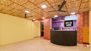 Un hall d’hôtel avec un plafond décoré, un comptoir d’accueil et un panneau indiquant que l’établissement est géré par OYO.