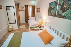 Une chambre à coucher avec un lit, une table de chevet, une lampe et un berceau.