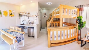 Un espacio habitable compacto con cocina, comedor y una litera.