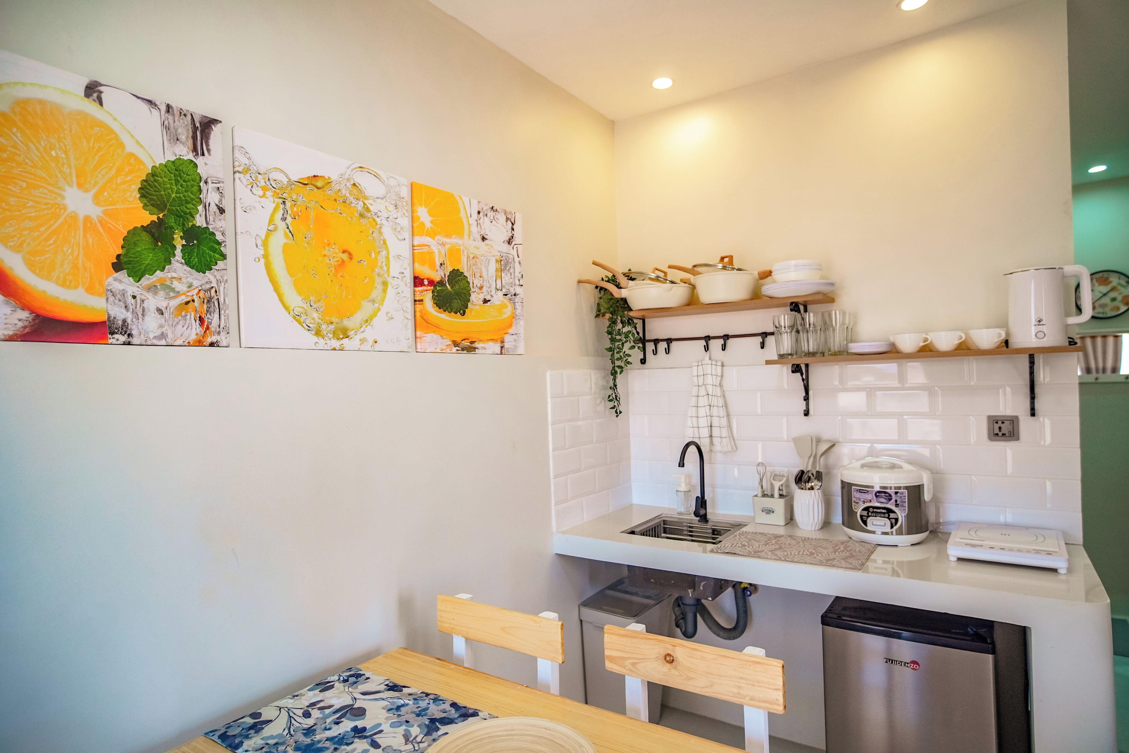 A modern kitchen with white tiles, a sink, a coffee maker, and a dishwasher.