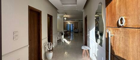 A hallway with a wooden wardrobe, a small table with a vase, and a mirror on the wall.
