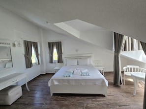 A bedroom with a large bed, bedside tables, a desk, and a chair. - MedVillas Dalyan (Dalyan)