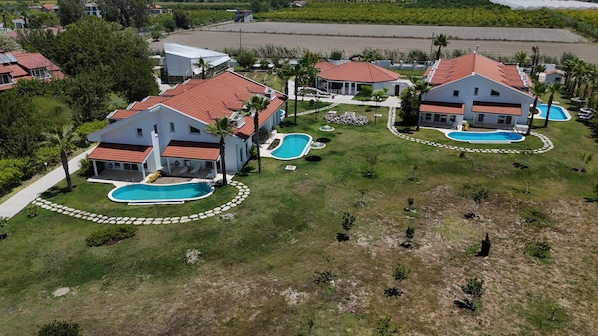 A residential area with houses, swimming pools, and a large open field. - MedVillas Dalyan (Dalyan)