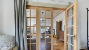 A room with a bed, a wooden sliding door, and a view of a living area. - Villa 'theMAP' with Balcony and Wi-Fi (Lenzkirch)