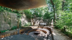 A circular outdoor seating area with a fire pit, surrounded by stone steps and wooden railings. - Villa 'theMAP' with Balcony and Wi-Fi (Lenzkirch)