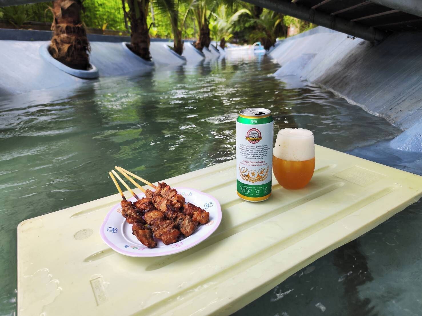 Ein Tisch mit einem Spieß voller Fleisch, einer Bierdose und einem Bierglas.