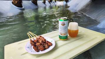 Ein Tisch mit einem Spieß voller Fleisch, einer Bierdose und einem Bierglas.