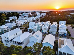 Un área residencial costera con casas modernas de varios pisos, techos planos y grandes ventanales.