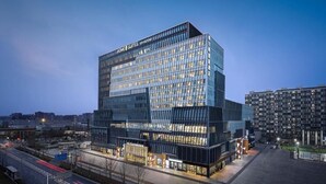 A modern hotel with a glass facade, multiple floors, and a prominent signage. - Home2 Suites By Hilton Beijing Shunyi  (Shunyi)