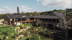 Un resort con un edificio grande, aree salotto all'aperto e uno stagno.