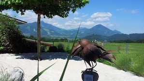 A sculpture of a bird in a garden with mountains in the background. - Room-charming Guest Room in Ebbs Austria (Ebbs)