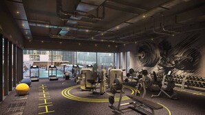 A gym with exercise equipment, a yellow ball, and a large window with a city view. - Stunning 2 Bed l Sea and City Views l Dubai Marina (Dubai Marina)