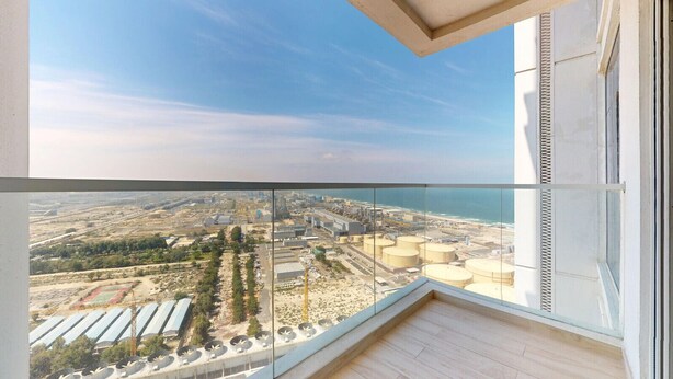 A balcony with a view of an industrial area and a beach. - Stunning 2 Bed l Sea and City Views l Dubai Marina (Dubai Marina)