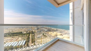 A balcony with a view of an industrial area and a beach. - Stunning 2 Bed l Sea and City Views l Dubai Marina (Dubai Marina)