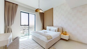 Ein modernes Hotelzimmer mit einem großen Bett, einem Schreibtisch und Blick auf die Stadt.
