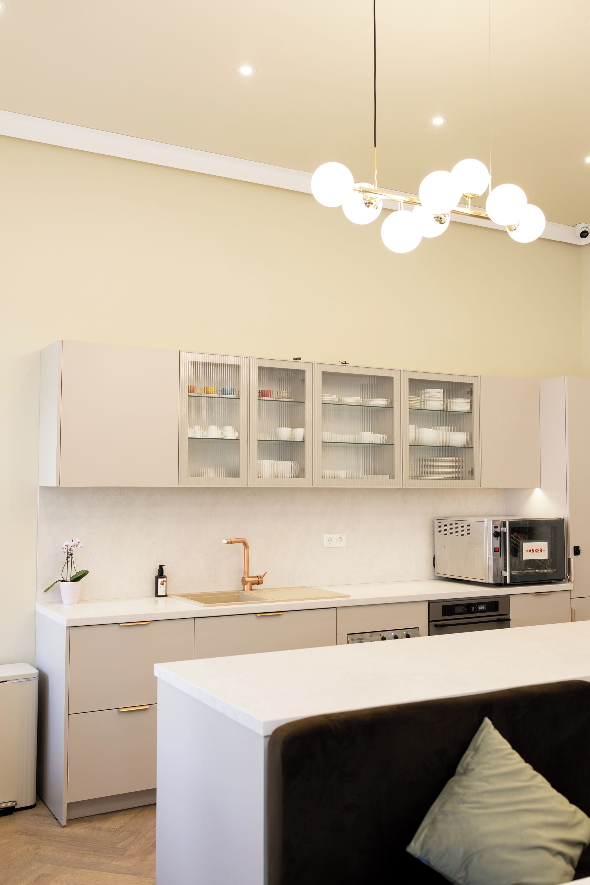 Une cuisine moderne avec des armoires blanches, une hotte de cuisinière en acier inoxydable et un lave-vaisselle intégré.