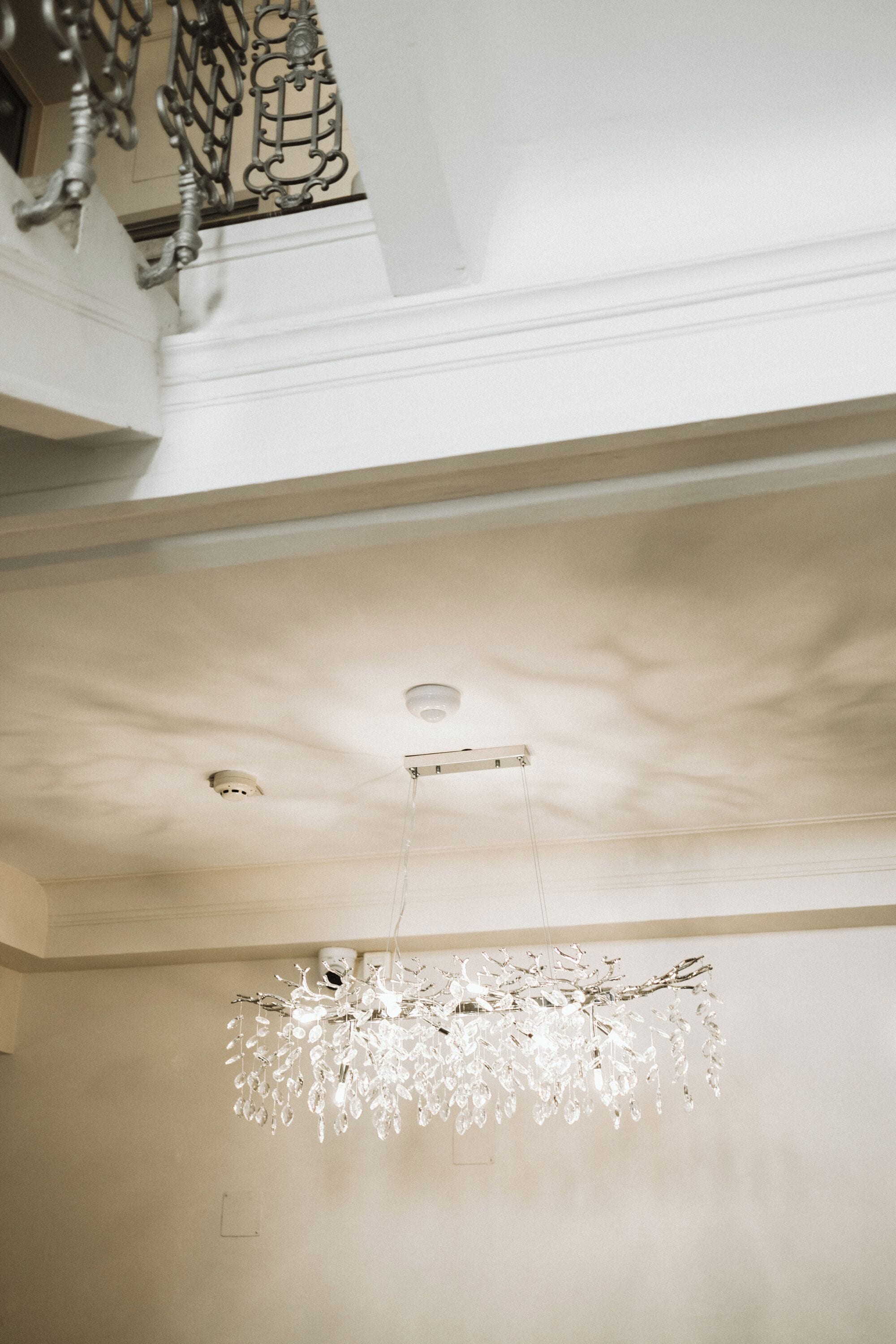 A chandelier with crystal elements hanging from a ceiling.