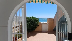 Een boogvormige doorgang die uitkomt op een balkon met uitzicht op zee.