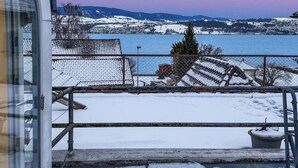 A snowy landscape with a view of a lake and distant mountains. - Elegant Lake Zurich House with Stunning Views and Private Terrace (Stäfa)