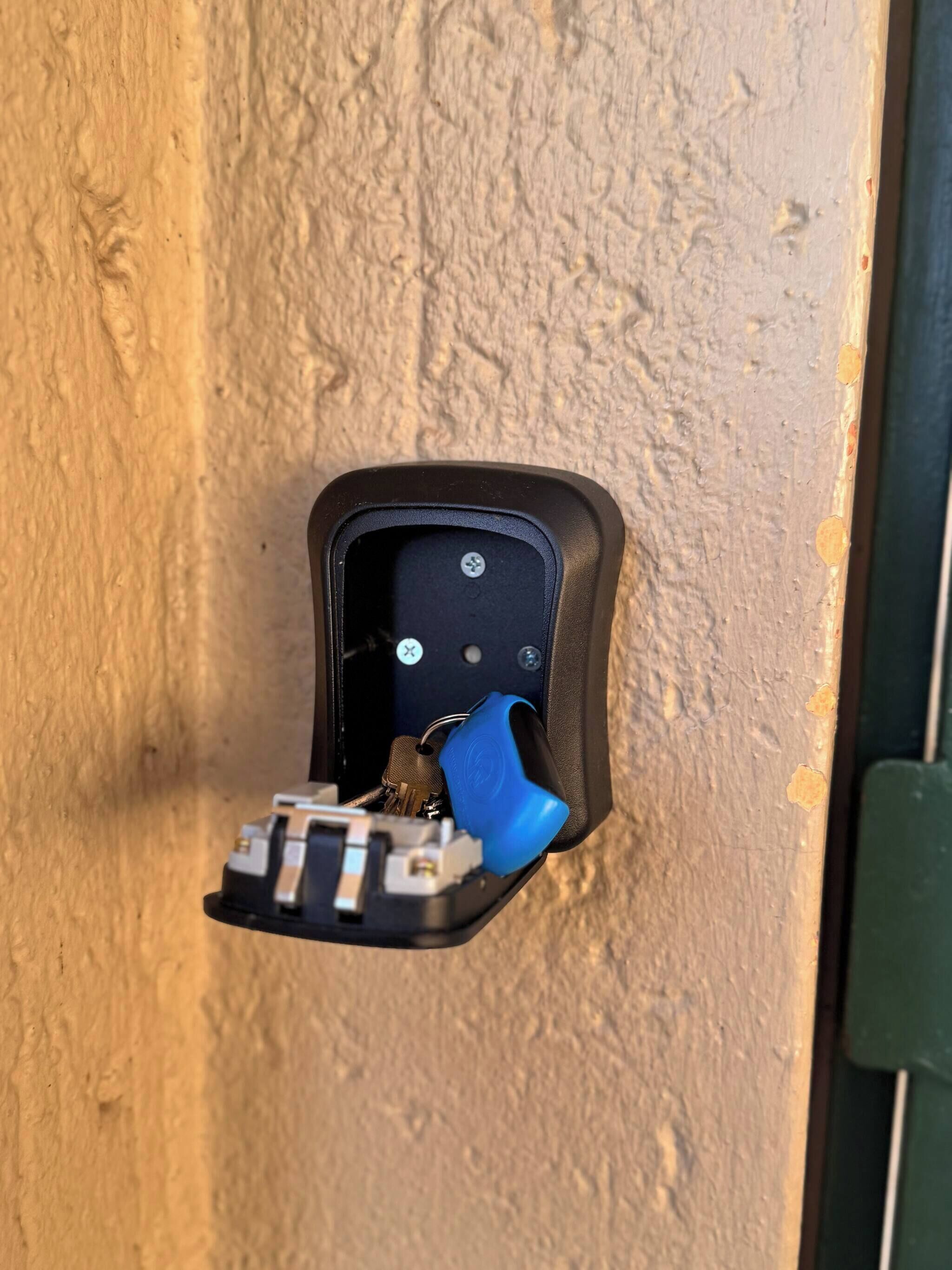 Un picaporte con orificio para llave y un llavero azul.
