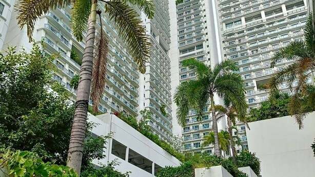 A high-rise building with multiple balconies, surrounded by greenery and staircases. - Lerfo Staycation!!!! (Mandaluyong City)