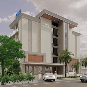 A modern hotel with a prominent entrance, multiple floors, and a visible sign for 'GK Conifer'.