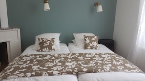 A bedroom with a bed, two wall-mounted lamps, a nightstand, and a fireplace. - House with garden, 20 minutes walk from the town centre (Yzeure)