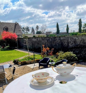 A patio with a table set for tea, chairs, and a garden view. - House with garden, 20 minutes walk from the town centre (Yzeure)