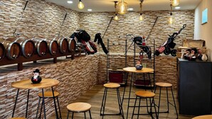 A room with wooden barrel wine racks, round tables, and stools. - Sandoco House - Pitch&putt Golf - Pool & Nature (Ponte de Lima)