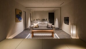 Un interior moderno con un sofá, una mesa de centro, un cuadro y un espejo.