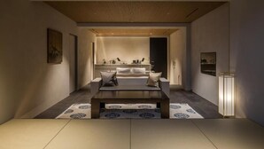 Un interior moderno con una zona de estar central, una cocina al fondo y un diseño minimalista.