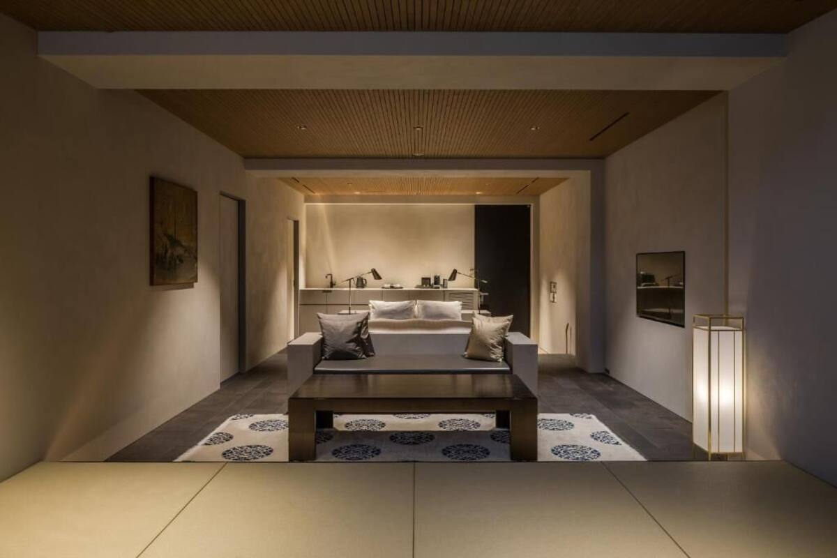 A modern interior with a central seating area, a kitchen in the background, and a minimalist design.