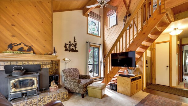 A cozy living room with a fireplace, a comfortable chair, a sofa, and a television. - 1 Mi to Shaver Lake! Family & Couples Condo (Shaver Lake)