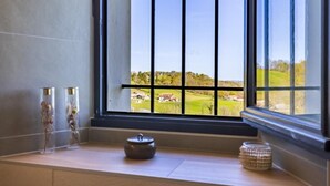 Una habitación con un ventanal grande, un banco de madera y vistas a un paisaje verde.