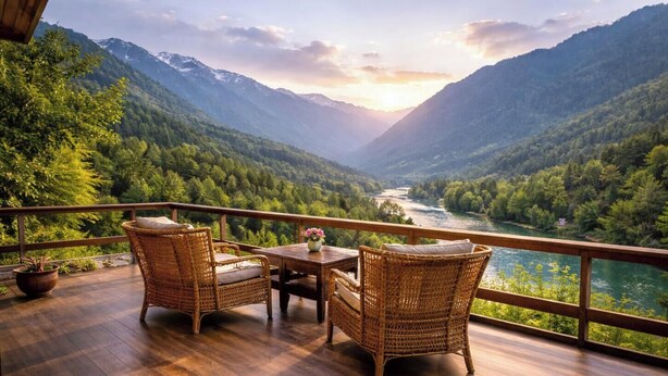 Een balkon met rieten meubels en uitzicht op een rivierdal.
