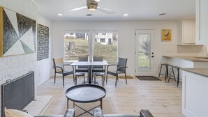 A modern kitchen with white cabinets, a dining area with a table and chairs, and a ceiling fan. - Overland Park Home Near Dtwn w/ Easy Hwy Access (Overland Park)