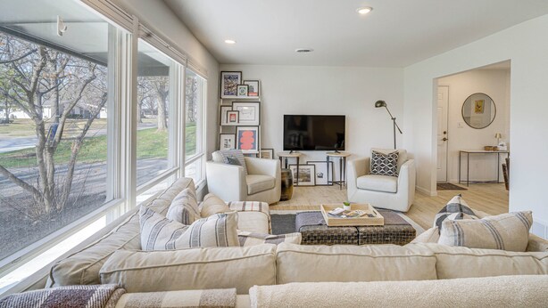 A spacious living room with a large window, a flat-screen TV, and a cozy seating area. - Overland Park Home Near Dtwn w/ Easy Hwy Access (Overland Park)