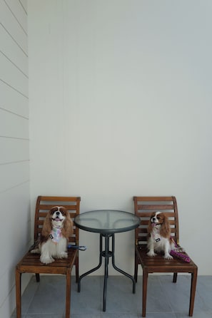 Two wooden chairs and a small round table in a corner. - Khao Yai Pool Villa - Private Pool, Mountain View, BBQ, Pets Friendly (Tambon Mu Si)