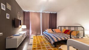 Ein Schlafzimmer mit Bett, Nachttisch, Lampe und einem kleinen Tisch mit Stühlen.