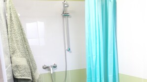 Une salle de bain avec une douche, un lavabo et des toilettes.