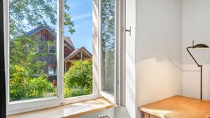 A room with a large window, a radiator below, and a wooden table.