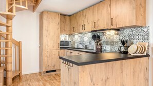 A kitchen with wooden cabinets, a microwave, a coffee maker, and a knife block.