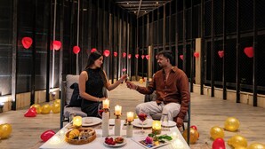 A couple seated at a table with candles, balloons, and a dessert spread. - Alaya Stays Parinita Farm 4 BHK Villa (Faridabad)