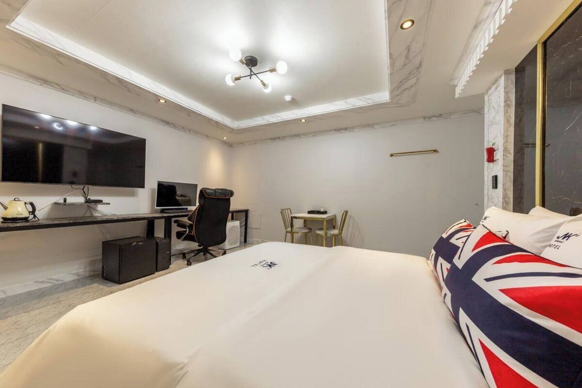 Une chambre d’hôtel comprenant un lit, un bureau, une chaise, une télévision et une petite table.