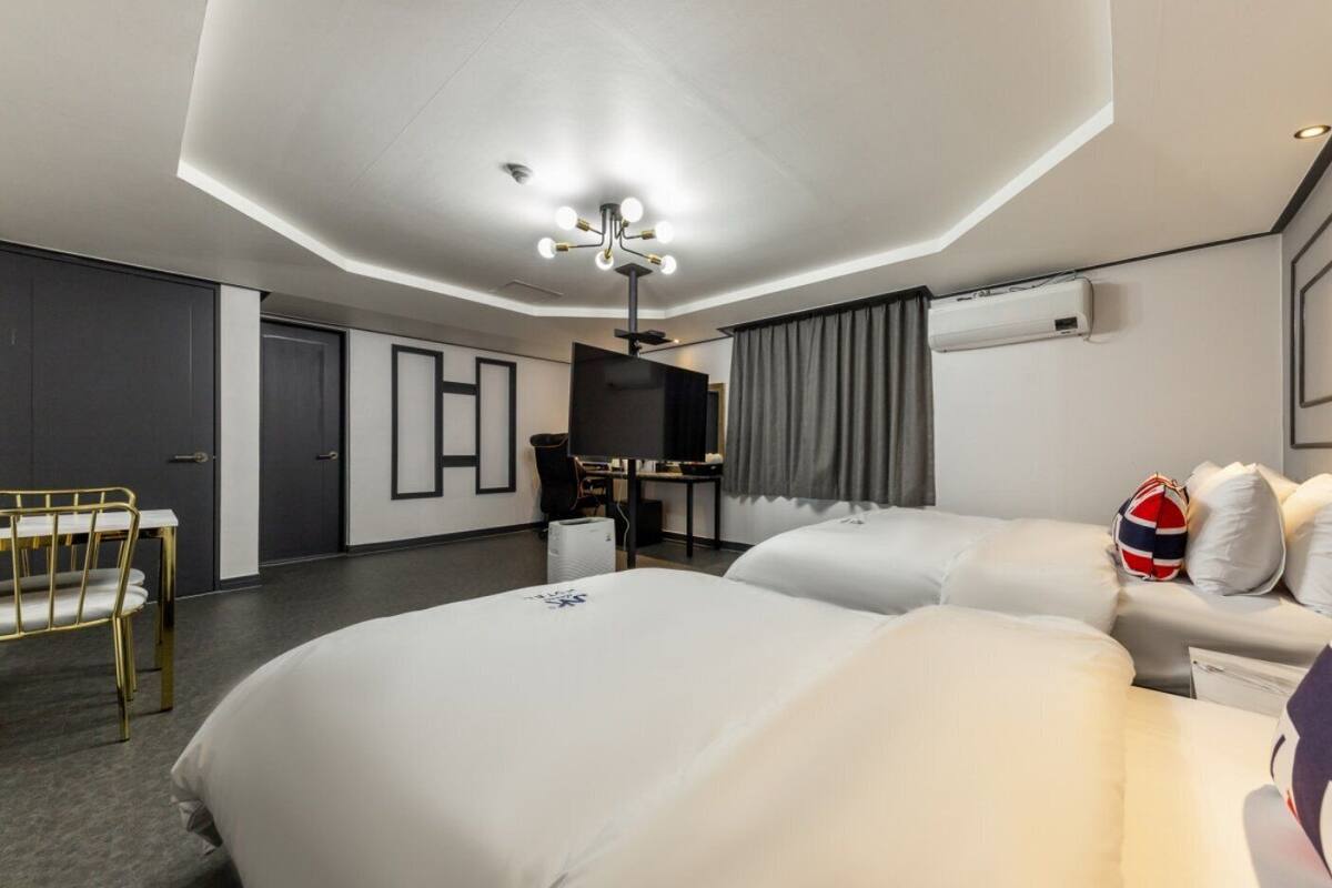 Une chambre d’hôtel moderne, dotée d’un grand lit, d’un bureau et d’une télévision.
