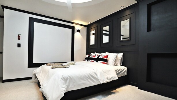 Ein modernes Schlafzimmer mit einem großen Bett, einem Kleiderschrank und einem Spiegel.