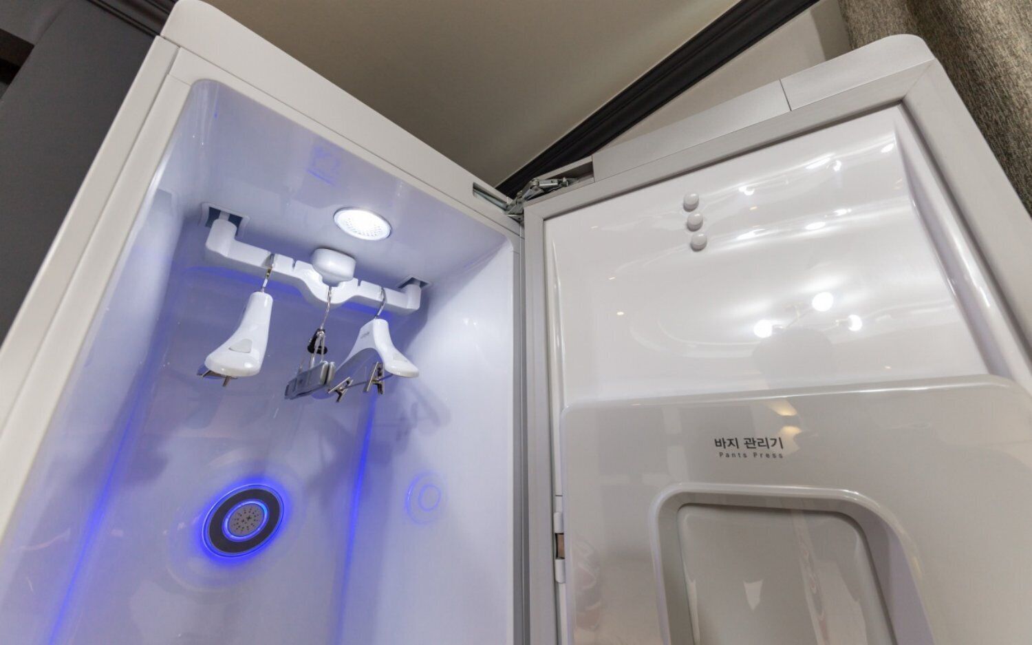 A bathroom with a white sink, a mirror, and a blue light.